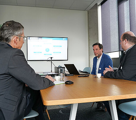 ICM-InnovationChallenge23: Während der Lösungspitches ist Überzeugungsarbeit gefragt. Prof. Robert Schulz (Mitte) und Markus  Schröppel (rechts) vom IFT der Universität Stuttgart versuchen Andreas Wolf (links) von robomotion davon zu überzeugen, dass sie die beste Lösung auf die Forschungsfrage des Unternehmens haben. (Bild: Daryoush Djavadi / KIT)