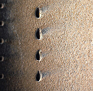 Detailed view of a row of diffuser holes on the hot gas side. The deflection of the cooling air jet can be seen from the discoloration. (Image: Institute of Thermal Turbomachinery / KIT)
