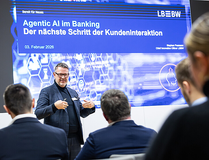 Stephan Paxmann, Chief Innovation Officer der LBBW, steht auf der Bühne während seines Vortrags über KI und Agentensysteme im Banking. (Foto: KIT)
