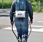 Ein Proband trägt das Exoskelett und läuft auf einem Asphaltweg. Auf dem Rücken trägt er Im Tragerucksack Akku und Antrieb. Um das Gewicht des mobilen Exoskeletts noch weiter zu reduzieren, werden auch Industriepartner aus der Batterieentwicklung gesucht. (Bild: Lehrstuhl für Hochperformante Humanoide Technologien / KIT)