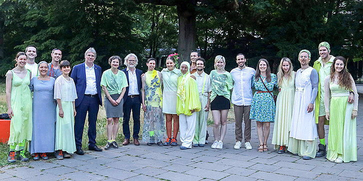 Nach der Premiere am Campus Süd des KIT: Gruppenbild der Mitwirkenden. Unter ihnen Präsident Prof. Holger Hanselka, Nike-Marie (Leitung Sparte Volkstheater) und Ulrich Peters (Intendant) (6. bis 8. von links) sowie die Projektleitenden Sabrina Toyen (Dramaturgin und Künstlerische Produktionsleiterin), Laura Bosch und Jan-Niklas Blötz (4. bis 6. von rechts).
