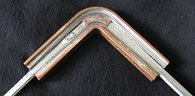 Etwa 6 Zentimeter lange Abschnitte der zu verbindenden Supraleiterkabel liegen im Kupferkörper des Verbinders. Anschließend werden die Kabel eingelötet und der Verbinder mit einem Deckel verschlossen.