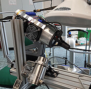 Der mikrowellenbeheizte Druckkopf sieht aus wie ein Fön in Metalloptik mit außen angebrachten Draht- und Kabelapplikationen. (Bild: KIT)