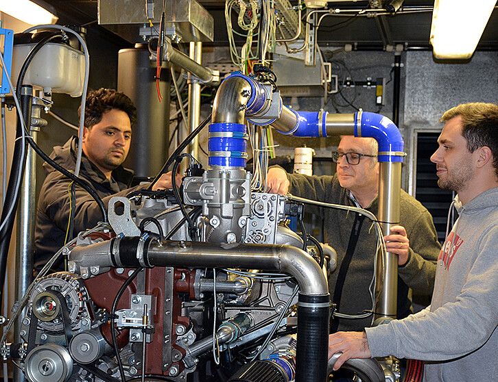 Am Institut für Kolbenmaschinen wird ein 1-Zylinder-Motor zu Testzwecken mit Wasserstoff betrieben. Uwe Wagner und sein Team testen unterschiedliche Modifikationen, wie etwa Brennraumdesign und Einspritztechnik, hinsichtlich des sicheren und effizienten Betriebs. Im Versuchsaufbau werden Verbrennungsunregelmäßigkeiten gemessen und analysiert, um sich der idealen Auslegung des Wasserstoff-Verbrennungsmotors anzunähern. (Bild: KIT)