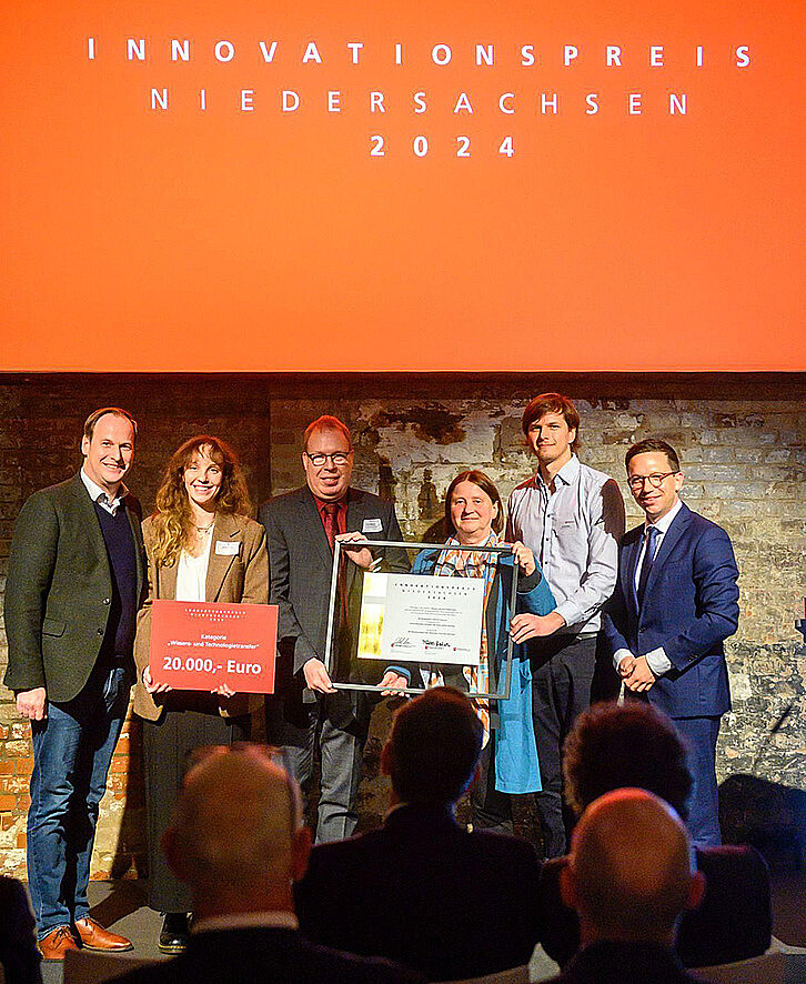 Die NanoDrug Delivery GmbH (NDD) erhält den Innovationspreis Niedersachsen 2024 in der Kategorie „Wissens- und Technologietransfer“. Die Auszeichnung nahmen in Hannover NDD-Finanzvorstand Phillipp Langrehr, Dr. Nathalia Ferreira, die Gründer*innen Prof. Dr. Claus Feldmann und Prof. Dr. Frauke Alves sowie NDD-Geschäftsführer Dr. David Rudolph vom Niedersächsischen Minister für Wissenschaft und Kultur, Falko Mohrs, entgegen (v.l.n.r.). (Foto: Henning Scheffen / Niedersachsen.next)