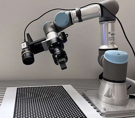 Der Roboter nimmt mit der intergierten Kamera einen Kalibrierkörper, eine Platte mit einem speziellen Gittermuster, aus verschiedenen Ansichten auf. Die Kalibrierung anhand von Ist- und Sollwerten optimiert die kinematischen Parameter des Roboters. (Bild: KIT)