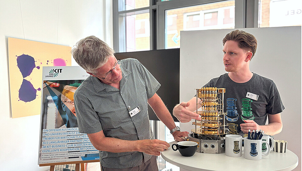 Dennis Rieger, Softwareentwickler bei QINU, und Simon Zühlke, Endress+Hauser SE + Co.KG, tauschen sich beim „Update Quantentechnologie“ über Kühltechnik für supraleitende Quantenschaltungen aus. (Foto: KIT)