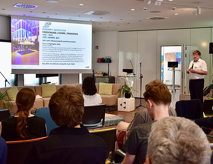 Prof. Thomas Hirth, Vizepräsident Transfer und Internationales, eröffnete den Industrietag der Wissenswoche NEULAND mit einem Impulsvortrag und betonte die strategische Bedeutung der Quantenforschung am KIT. Eine Gruppe von Teilnehmenden verfolgt aufmerksam seine Präsentation. (Foto: KIT)