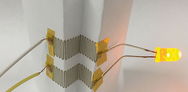 Demonstration of deformable electronics: Folded circuit on paper with LED lamps. The printed structures can be bent, folded and even twisted.