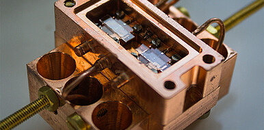 Prototyp der supraleitenden Quantenschaltung, gefertigt im Labor am KIT. Im Inneren des ca. 1 cm hohen Kupferträgers befinden sich zwei Qubits und dazwischen ein Koppler. Mit mehreren Modulen ist die Leistung skalierbar. (Bild: IQMT / KIT)